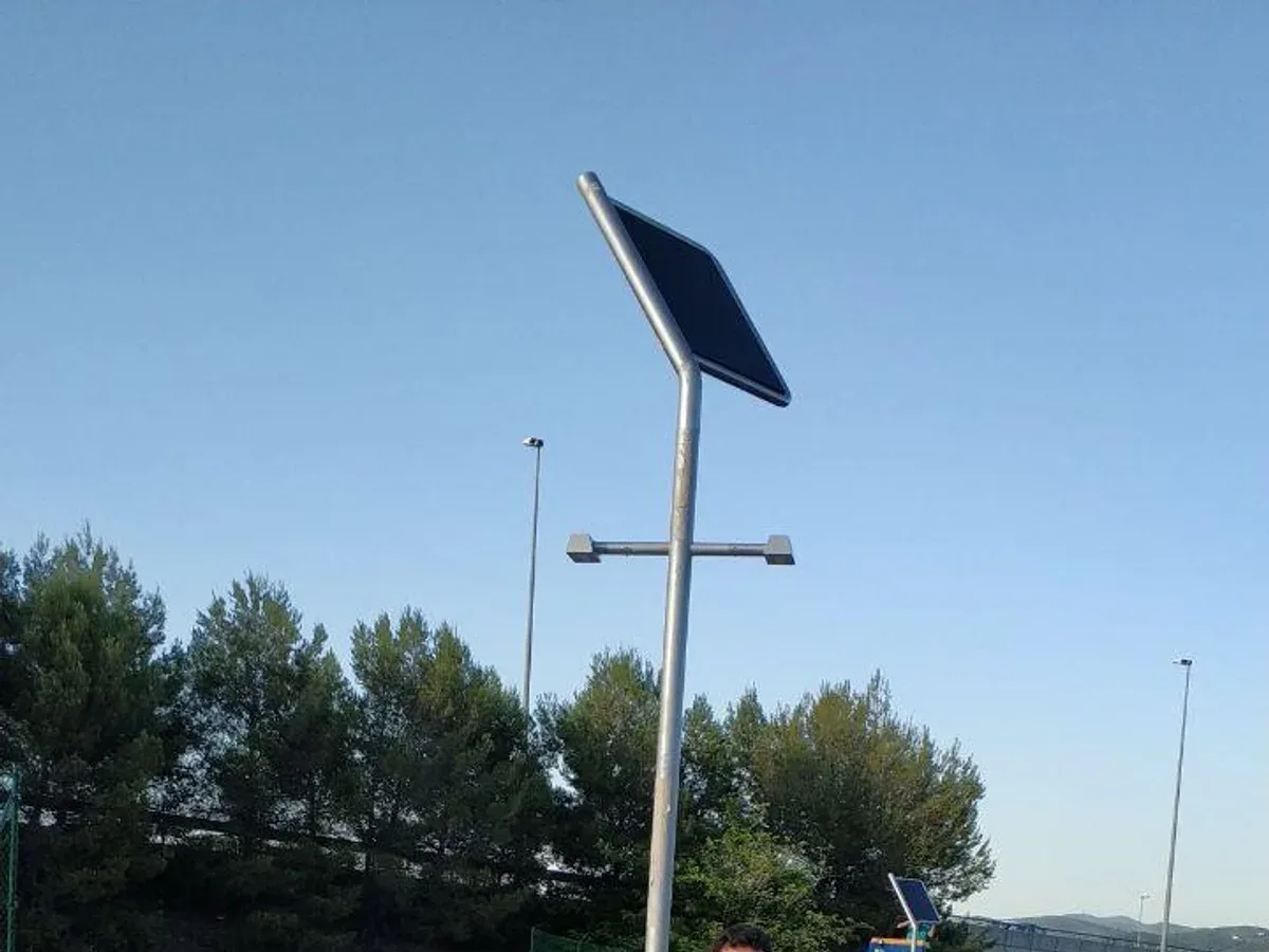 Farola solar instalada en vía pública, con su panel fotovoltaico y sus dos luminarias LED